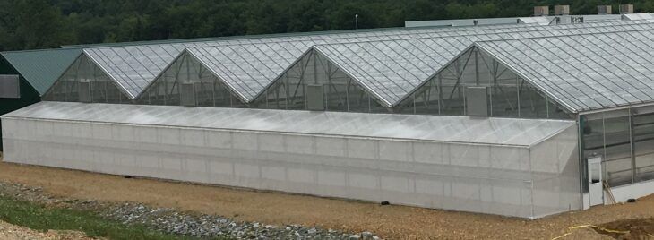 Vail facility with exhaust fans in roof and insect netting lean-to