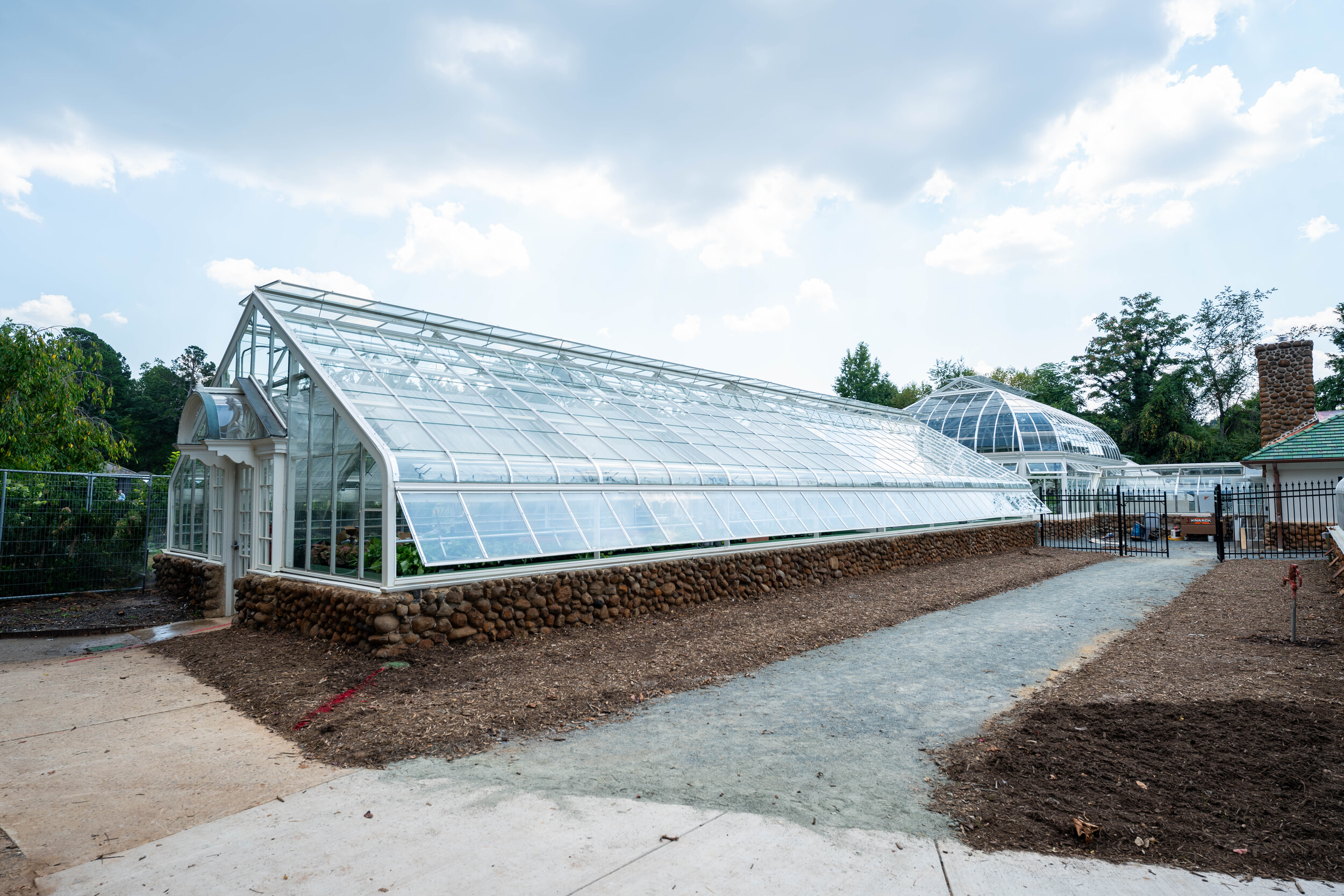View of side glass greenhouse connected to Reynolda Conservatory with gutter vent